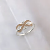 Ring with sand · Silver infinity intertwined with sand or earth