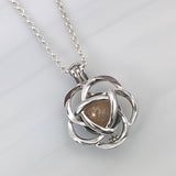 Pendant with sand · Silver flower cage with pearl and sand or earth