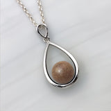 Pendant with sand · Silver and pearl drop or teardrop with sand or earth