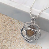 Pendant with sand · Silver flower cage with pearl and sand or earth